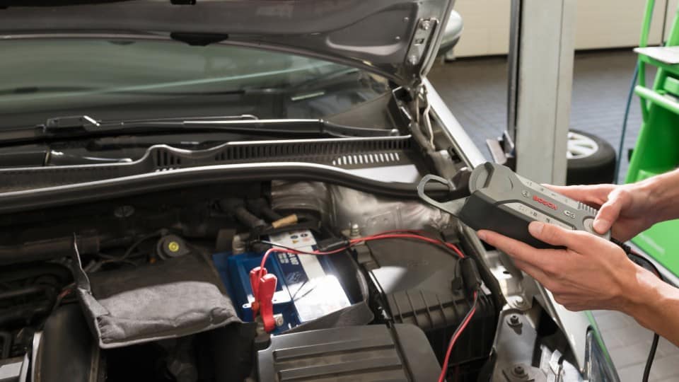 Imagen de un mecánico revisando la batería de un coche